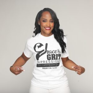 Woman smiling and pointing at her logo T-shirt.