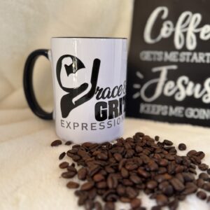 A white coffee mug with bold black text, surrounded by scattered coffee beans.