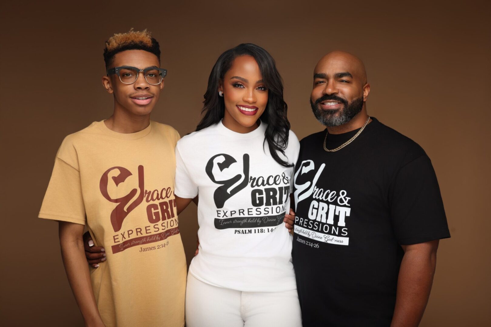 Three people wearing matching brand t-shirts, smiling together.