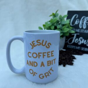 White coffee mug with 'Jesus Coffee And A Bit Of Grit' text on a table.