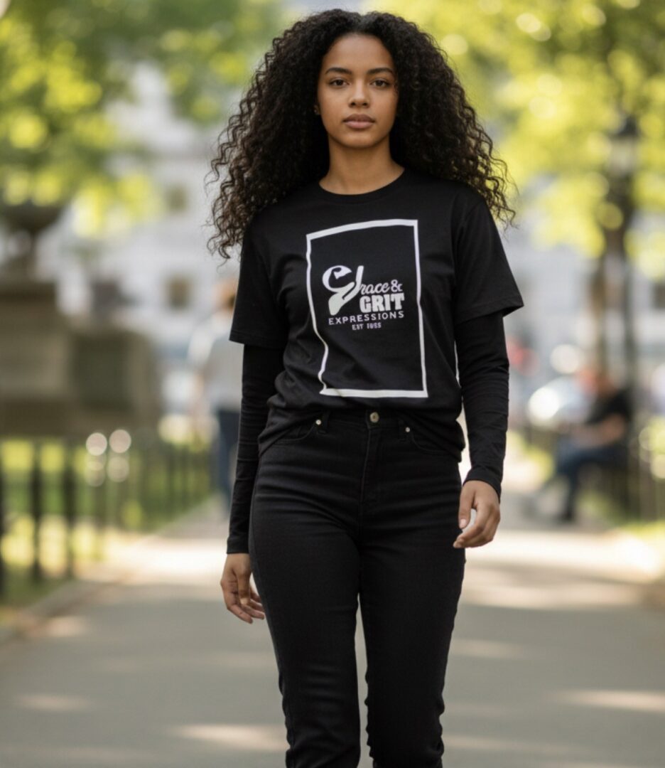Young woman walking outdoors in casual black outfit with graphic t-shirt.