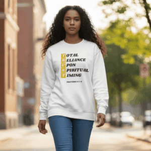 Woman wearing a white sweatshirt with a motivational message outdoors.