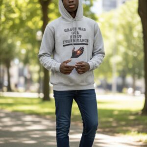Person wearing a hoodie and jeans standing on a sunlit park path.
