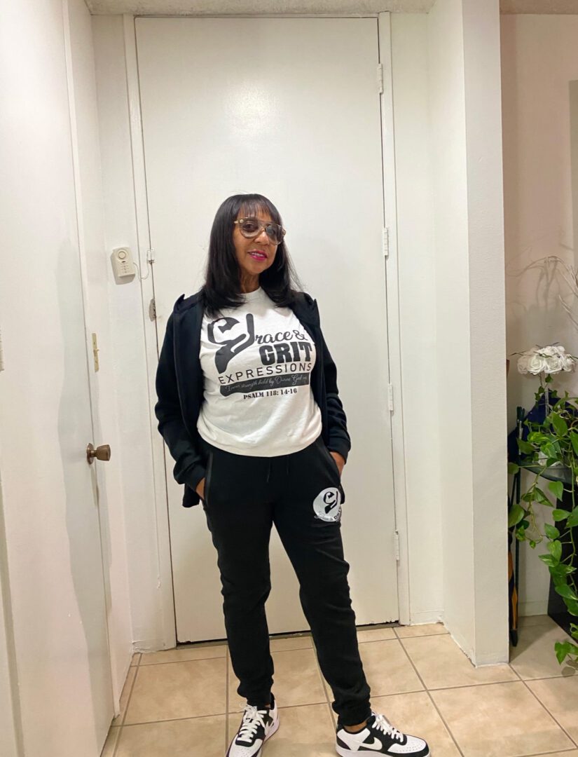 Woman posing indoors, dressed casually in a sweatshirt and sweatpants.