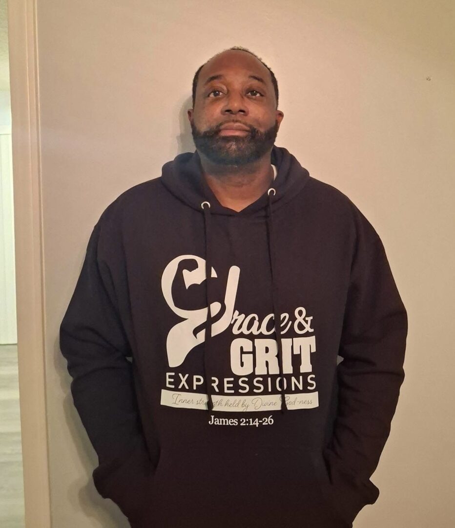 Man wearing a black hoodie with 'Choc & Grit Expressions' logo.