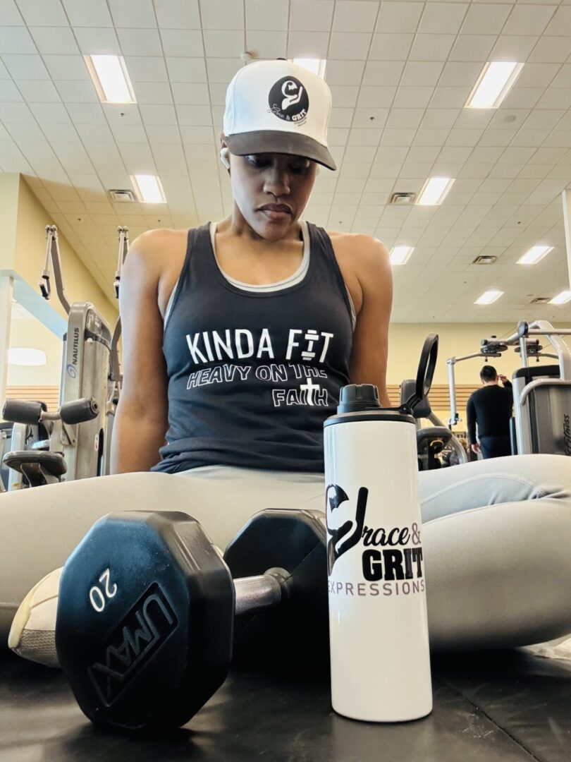 Person in gym attire with dumbbells and a water bottle.
