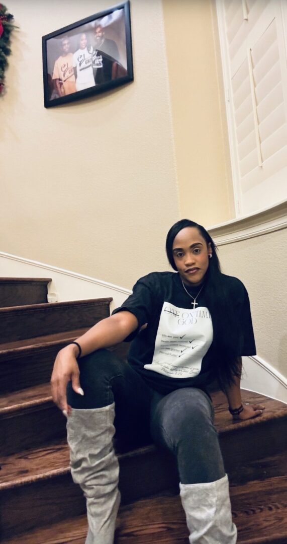 Person sitting on stairs, wearing a black and white outfit.