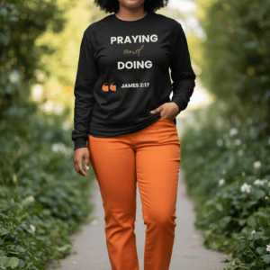 Person walking outdoors wearing a black shirt with a motivational quote and orange pants.