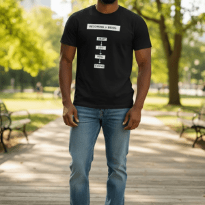 Man wearing a black graphic t-shirt and blue jeans in a park.